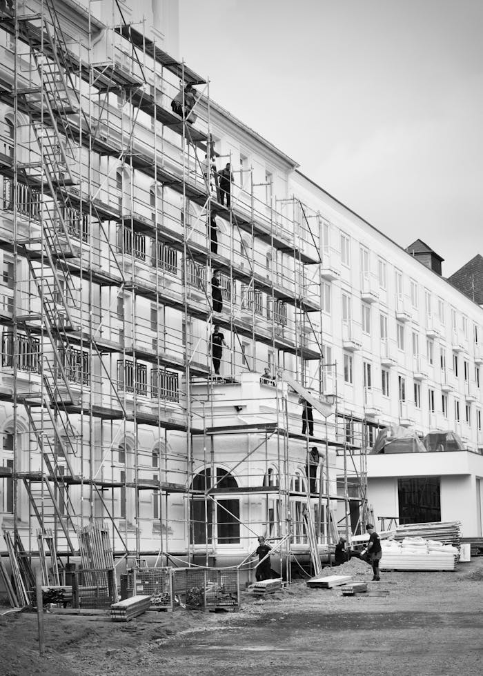 gallery-3 Black and white photo of a historic building under renovation with scaffolding.