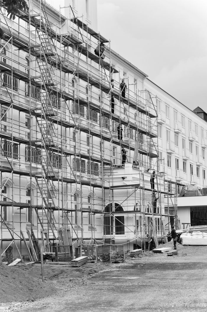 gallery-6 Black and white photo of scaffolding on a historic building facade under renovation.